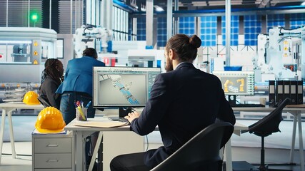 Photovoltaics factory expert looking over specifications on documents to ensure robot arms placing...