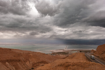 A cloudy sky with a car driving on a road