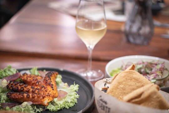 Grilled octopus, salad and white wine enhancing culinary experience in merida