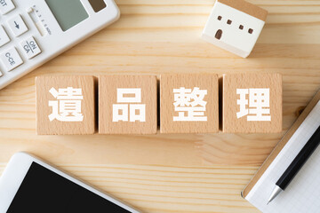 遺品整理と書かれたブロック、電卓、家の模型