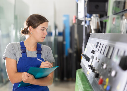 Portrait of foreman girl with folder of documents in a glass workshop
