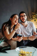 Young caucasian couple smile and play video games on joystick 