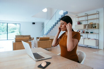 Woman sitting in living room using laptop looking at cam talk by video call with business friend...