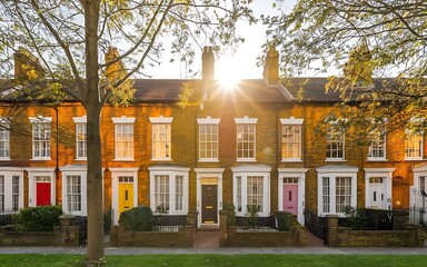Classic red-brick terraced houses in London, featuring Victorian architecture, chimneys, and small gardens. A timeless part of British cityscapes.