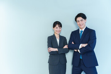 腕組みをするビジネスパーソン　ブルーバック