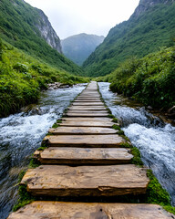 Fototapeta premium Wooden path across mountain stream, lush valley