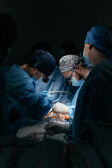 A team of experienced surgeons performing a complex operation with full concentration in well-lit operating room. Professional Medical Doctors Performing Surgery. Technology, Cardiology, Medicine