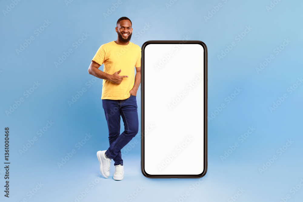 Aufkleber positive african american guy pointing at big smartphone with mockup for mobile app, recommending co