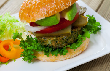 Vegetarian hamburger with soybean patty, tomato, avocado, cucumber and lettuce