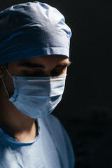Portrait of a male doctor in scrubs uniform. Man surgeon in a protective cap and face mask...