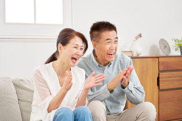 Fototapeta premium テレビを見るシニアの夫婦 リビング