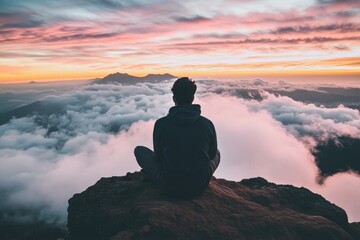 Person Meditating on Mountain Peak Above Clouds at Sunset