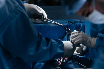 Multi-ethnic healthcare workers performing surgery on patient at operation theater. Medical...