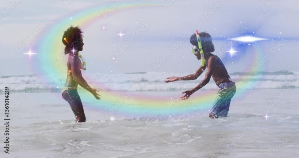 Poster children playing in ocean waves with rainbow and sparkles animation overlay