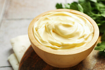 Delicious mayonnaise sauce in bowl on table, closeup