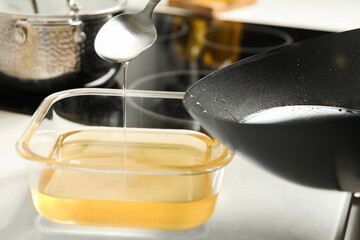 Pouring used cooking oil at white countertop, closeup