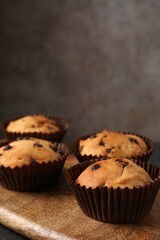 Delicious muffin with chocolate chips on table, closeup