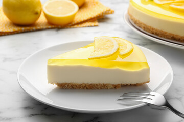 Piece of tasty lemon cheesecake and fork on white marble table, closeup