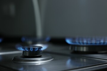 Gas burners with blue flame on stove, closeup