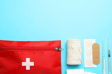 Flat lay composition with first aid kit on light blue background, space for text
