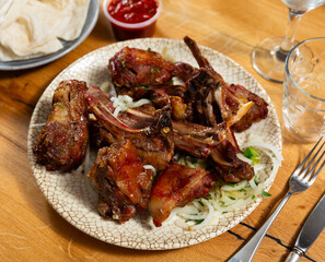 Delicious grilled lamb shashlik garnished with fresh onion slices served on white plate