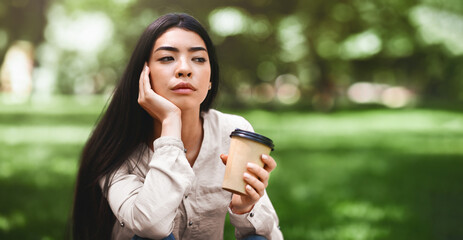 Coffee Break Outdoors. Pensive Asian Girl Enjoying Takeaway Drink In Park, Daydreaming And Thinking...