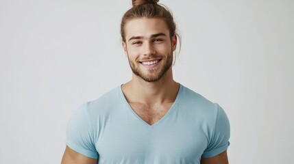 Fototapeta premium Smiling young caucasian male with man bun wearing light blue shirt