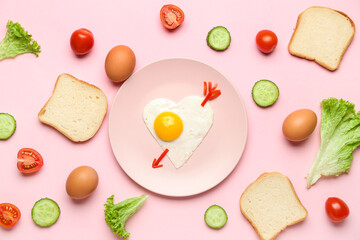 Plate with cute children's breakfast, eggs, vegetables and bread on pink background