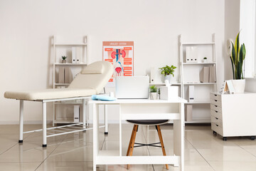 Interior of medical office with workplace, couch and shelf units