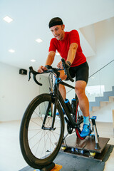 A triathlete riding a triathlon bike on a machine simulation in a modern living room