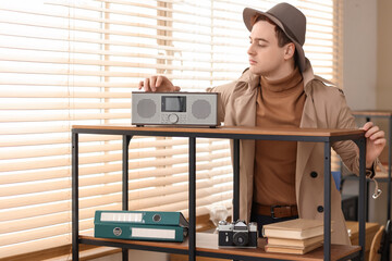 Male spy inspecting radio receiver in office