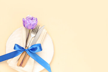 Table setting with tulip on beige background. Mother's day concept