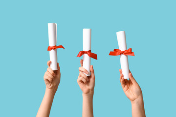 Female hands with diplomas on blue background