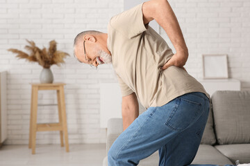 Mature man suffering from back pain at home