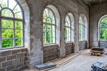 Obraz premium Interior of building under renovation or remodeling, arched windows and walls with concrete blocks, real estate