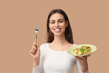 Beautiful young woman with plate of tasty ravioli on brown background