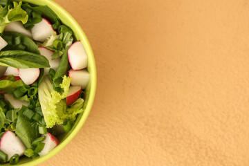 Bowl of tasty salad with radish on color background
