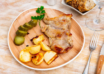 Delicious pork steak served with potatoes and pickles. Festive dinner