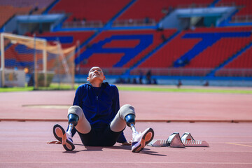 Asian para-athlete with prosthetic blades leg in stadium practicing workout for Paralympic running competition. Amputee sportsman runner practicing running workout. Disabled athlete man sport concept.
