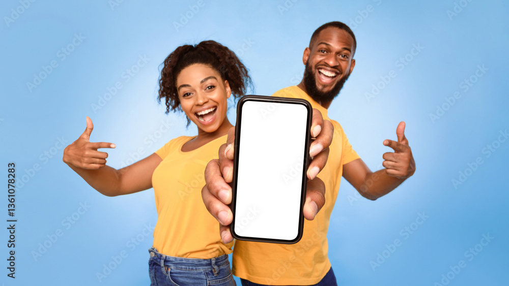 Poster use this new mobile app. joyful african american couple pointing at smartphone with empty white scre