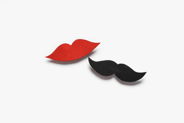 Male mustache and female lips made of paper isolated on white background