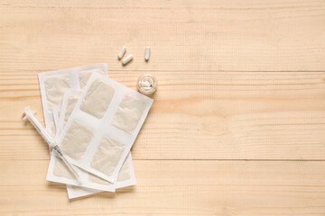 Mustard plasters with syringe and pills on wooden background