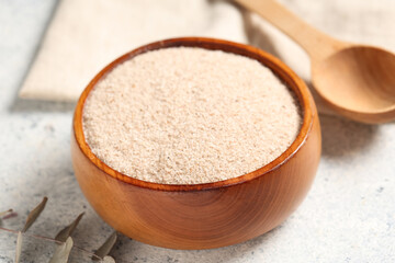 Bowl with psyllium husk powder on light background