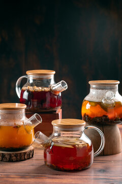 Various types of tea in teapots on a wooden table. Tea fruit hot drinks for health