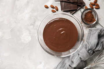 Bowl with hot chocolate, napkin and cocoa in sieve on grunge grey background. Top view