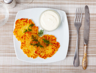 Fried grated potato pancakes with sour cream and dill, traditional Belarusian dish draniki