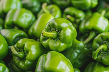 Green bell peppers stacked on each other background