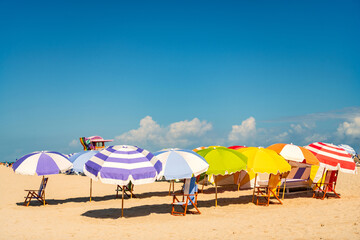 Sea relax under beach umbrella. Travel to sea. Sand exotic beach with umbrella. Sunny weather at beach sun. Summer vacation. Beach vacation at sea in summer. Travel agency