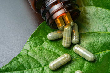 Herbal capsules Betel pepper leaf, pills Wildbetal leafbush, green leaf on a black background