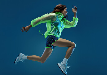 Woman in Neon Sport Outfit Running on Blue Background